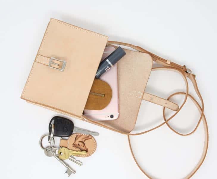 Small leather shoulder bag open showing contents