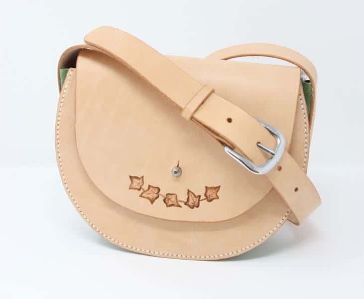Round leather shoulder bag against white background