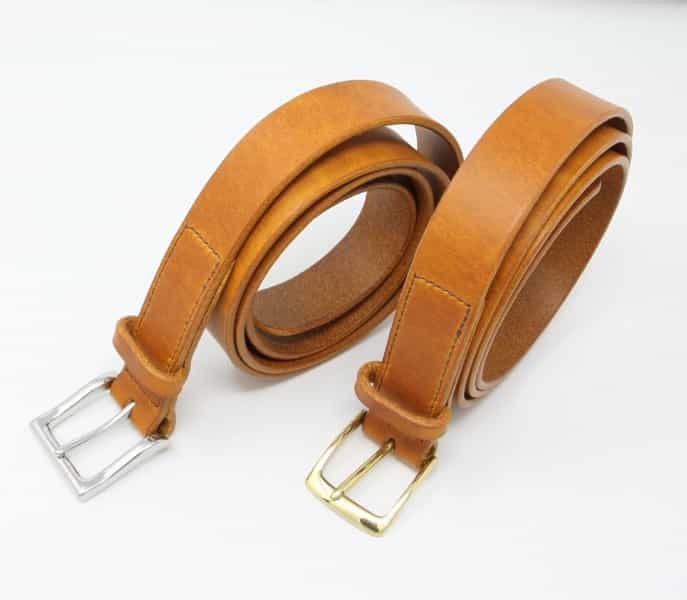 Italian tan leather belts. One with shiny nickel buckle and one with shiny brass buckle