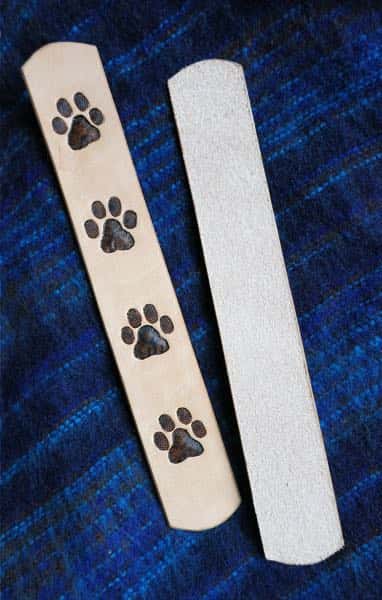Large paw print motif laether bookmark on blue cloth background