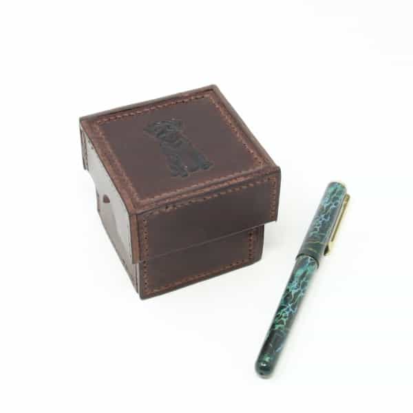 Small square box with border terrier motif, shown with pen for size comparison
