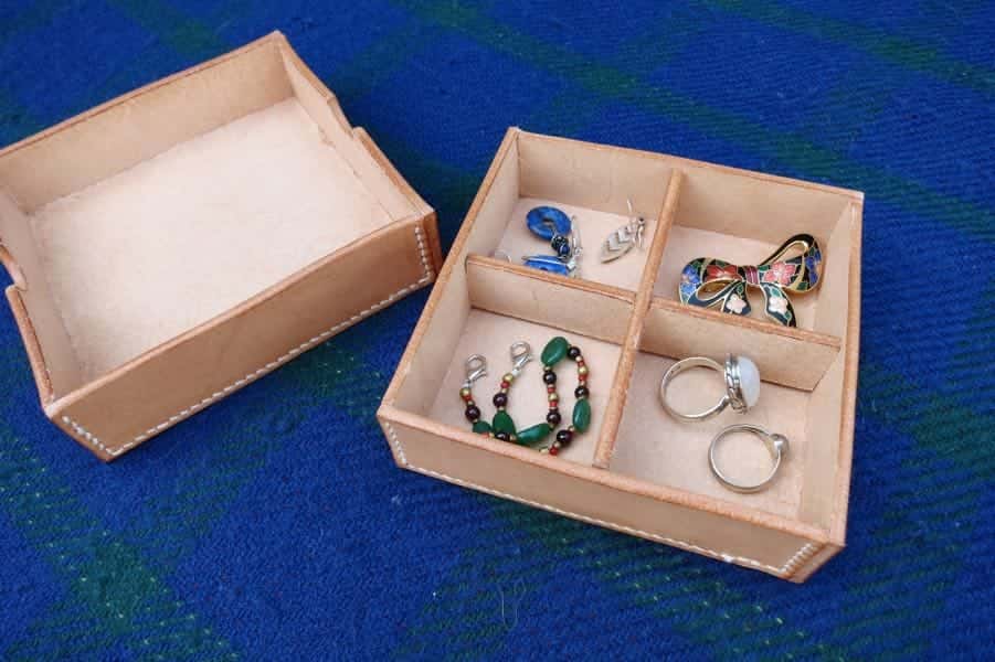 Shallow square leather box with jewellery
