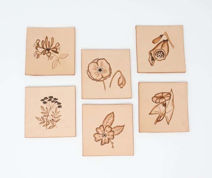 Set of six square leather drinks coasters with various flower motifs