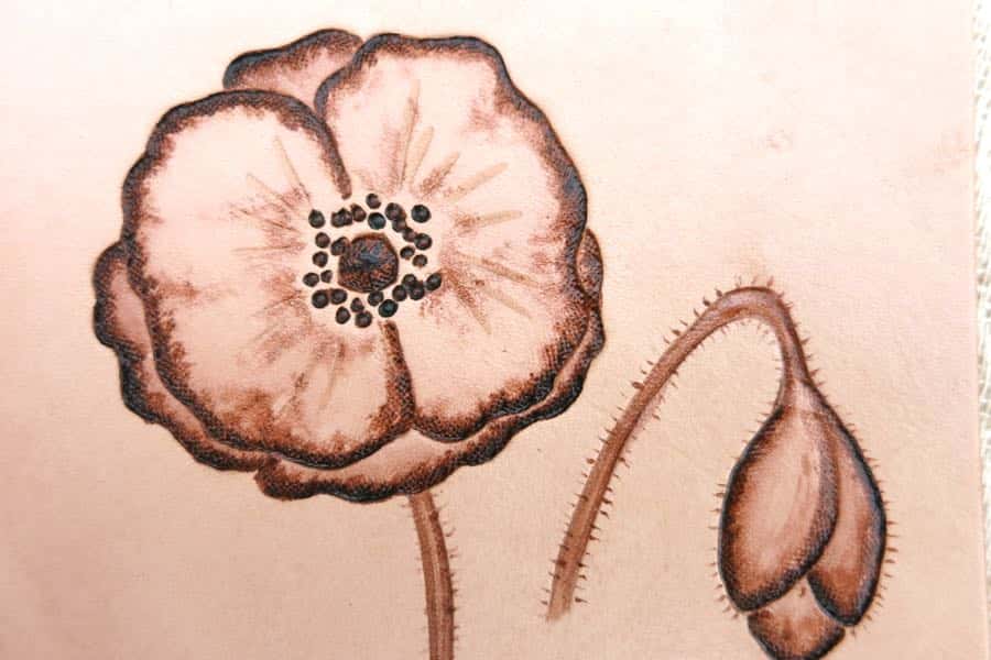 Detail of poppy motif on a square leather drinks coaster