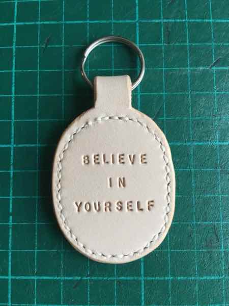 Oval leather key fob / key ring with believe in yourself phrase stamped on it.