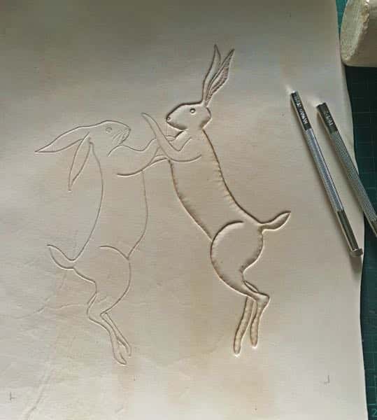 embossed picture of boxing hares in leather being made