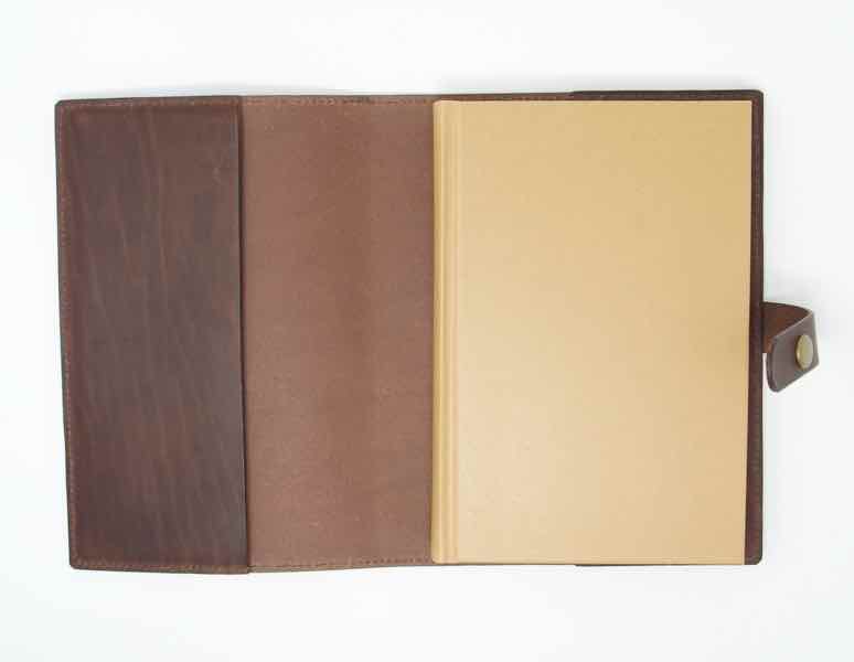 Brown leather journal cover open showing closed notebook