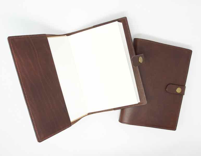 2 brown leather journals one of which is open showing the notebook inside
