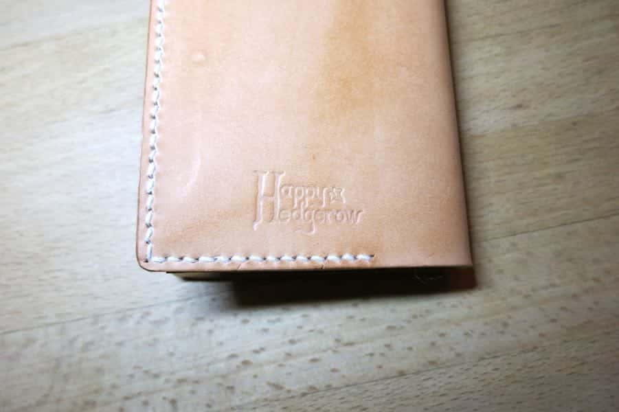 Happy Hedgerow logo on bottom of leather phone case