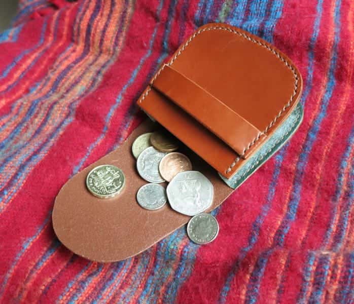 Open large brown leather pouch showing money