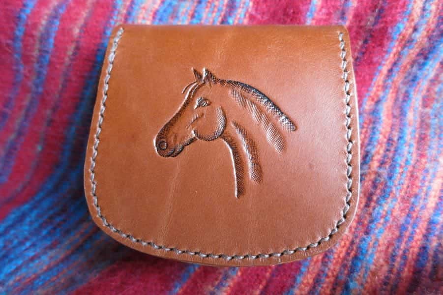 Back of large brown leather pouch showing horse head motif