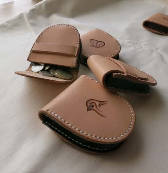 Small leather pouches with one open being used as a coin purse