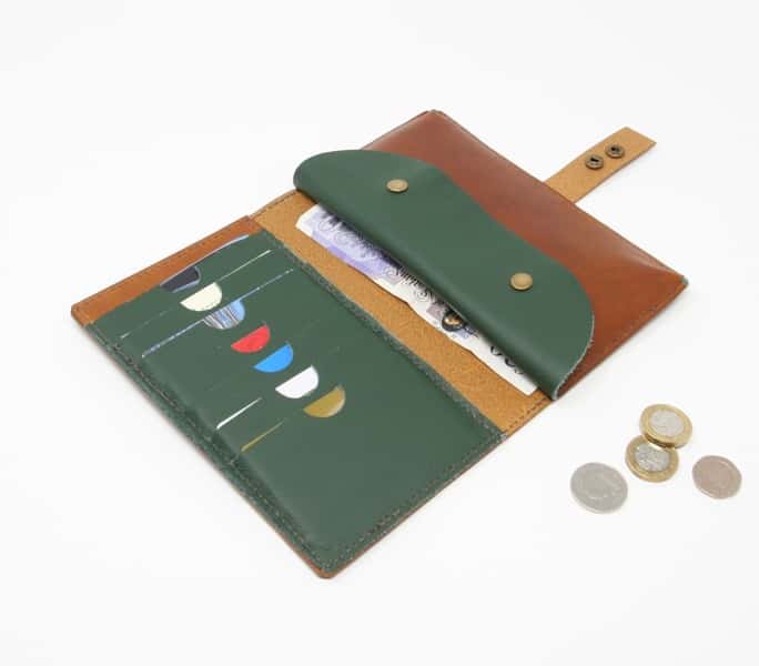 Tan leather wallet style purse with green interior shown open