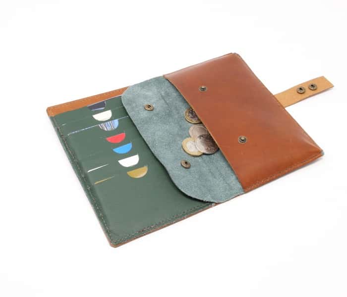 Tan leather wallet style purse with green interior shown open